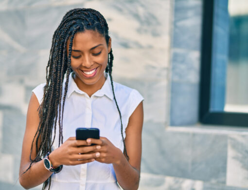 Young,African,American,Woman,Smiling,Happy,Using,Smartphone,At,The